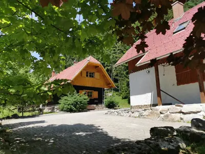 a large wooden house with a red roof at APARTMENTS ROGLA LUKANJA 1 in Oplotnica