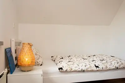 a bedroom with a bed and a vase on a table at Little Oasis Apartment in Zgornje Gorje