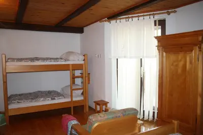 a room with two bunk beds and a couch at Penzion Sinji vrh in Zoll