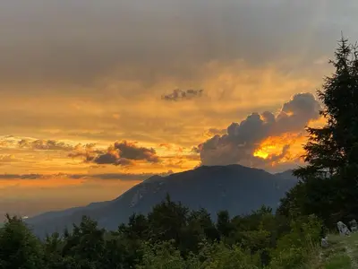 a sunset with a mountain in the background at Penzion Sinji vrh in Zoll