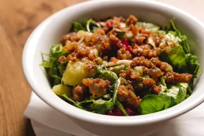 a salad in a white bowl on a table at Guesthouse Grof in Vransko