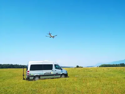 a van parked in a field with an airplane at Guesthouse Grof in Vransko