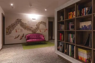 a reading room with a purple chair and books at Guesthouse Grof in Vransko
