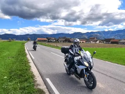 two people riding motorcycles down a road at Guesthouse Grof in Vransko