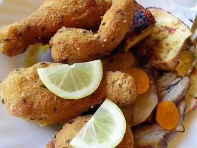 a plate of fried food with lemon slices on it at Holiday Home Urlaub für die Seele - Ferienhaus mit Sauna by Interhome in Rucmanci