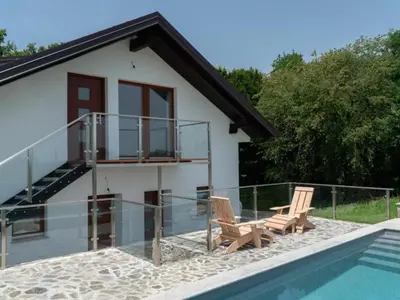 a house with a swimming pool and two chairs next to a house at Apartment Natur- und Weinresort Lipej by Interhome in Bizeljsko