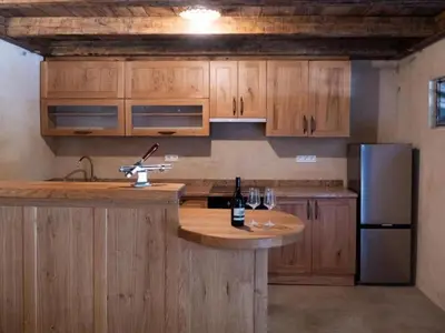 a kitchen with wooden cabinets and a counter with wine glasses at Apartment Natur- und Weinresort Lipej by Interhome in Bizeljsko