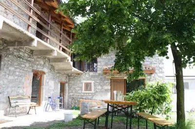a table and benches in front of a stone building at Vale