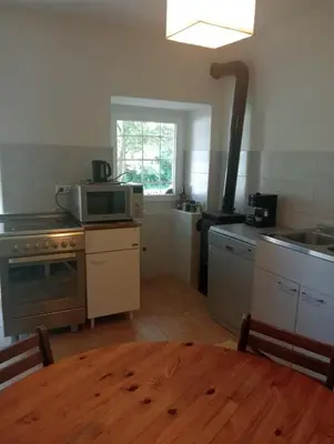 a kitchen with a table with a microwave and a stove at Vale