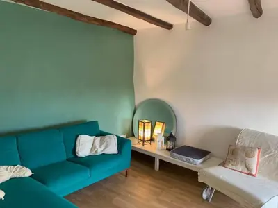 a living room with a blue couch and a mirror at Vale