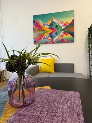 a purple vase with a plant in it on a table at ARIA apartment in Maribor