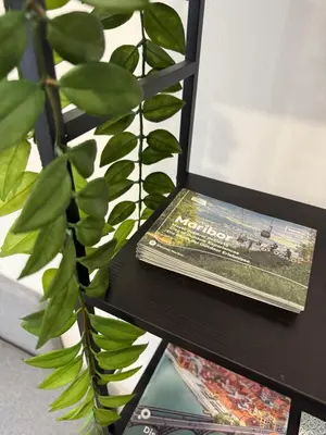 a book sitting on a table next to a plant at ARIA apartment in Maribor