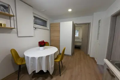 a white table with yellow chairs and a vase of flowers on it at Quiet One-Bedroom Near City Center Free Parking in Ljubljana
