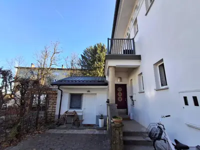 a white house with a balcony on top of it at Quiet One-Bedroom Near City Center Free Parking in Ljubljana