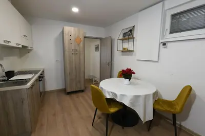 a small kitchen with a white table and yellow chairs at Quiet One-Bedroom Near City Center Free Parking in Ljubljana