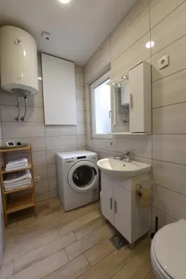 a bathroom with a washing machine and a sink at Quiet One-Bedroom Near City Center Free Parking in Ljubljana