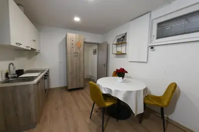 a small kitchen with a table and yellow chairs at Quiet One-Bedroom Near City Center Free Parking in Ljubljana