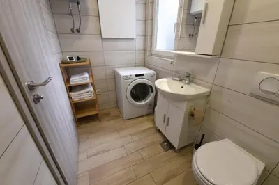 a small bathroom with a washing machine and a sink at Quiet One-Bedroom Near City Center Free Parking in Ljubljana