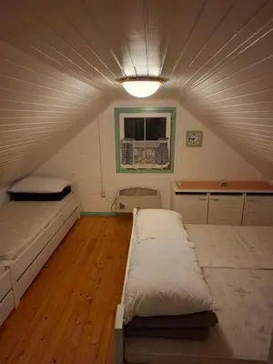 a room with two beds and a ceiling at Brunarica Beti in Brežice