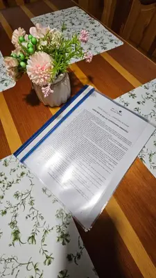 a table with a book and flowers on it at Brunarica Beti in Brežice