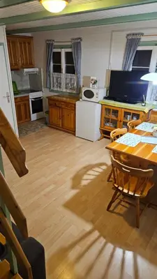 a living room with a table and a kitchen at Brunarica Beti in Brežice