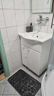 a bathroom with a white sink and a mirror at Brunarica Beti in Brežice