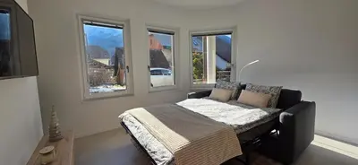 a bedroom with a bed in a room with windows at River2Mountain Cozy Apartment in Gozd Martuljek