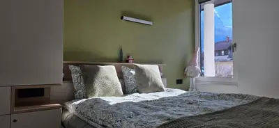 a bedroom with a bed with pillows and a window at River2Mountain Cozy Apartment in Gozd Martuljek