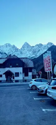 a parking lot with cars parked in front of a building at River2Mountain Cozy Apartment in Gozd Martuljek
