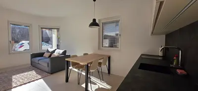 a living room with a table and a couch at River2Mountain Cozy Apartment in Gozd Martuljek
