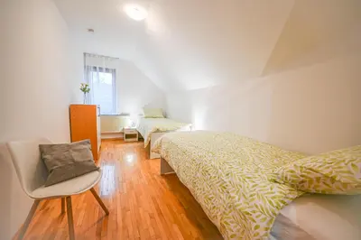 a bedroom with two beds and a chair in it at Green View Kamnik in Kamnik