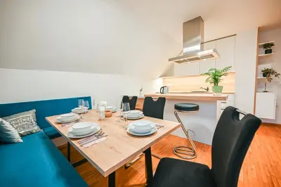 a dining room with a table and a blue couch at Green View Kamnik in Kamnik