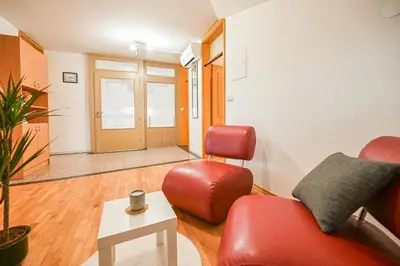 a living room with a red couch and a chair at Green View Kamnik in Kamnik