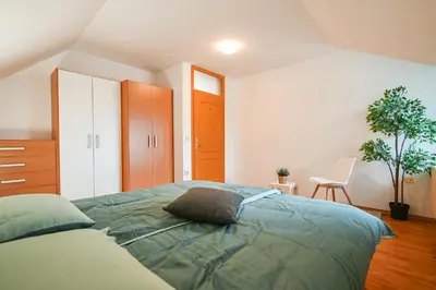 a bedroom with a bed and a chair in it at Green View Kamnik in Kamnik
