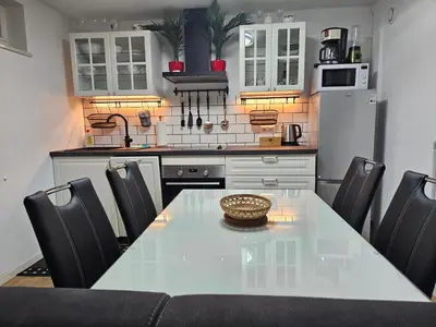 a kitchen with a white table and black chairs at Apartment Berglez in Škofja Loka
