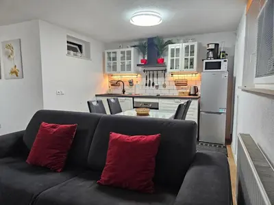 a living room with a couch and a kitchen at Apartment Berglez in Škofja Loka