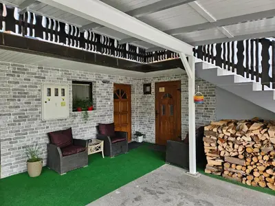 a patio with two chairs and a staircase with green grass at Apartment Berglez in Škofja Loka