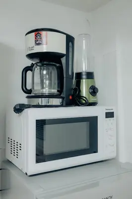 a microwave with a coffee maker on top of it at Apartment Berglez in Škofja Loka