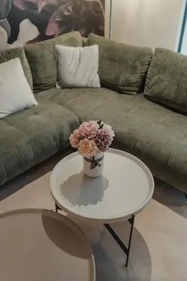 a living room with a couch and a table with flowers on it at City Residence in Ljubljana