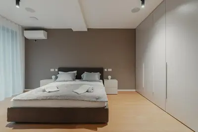 a bedroom with a large bed and a brown wall at City Residence in Ljubljana