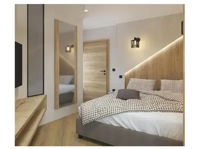 a bedroom with a large bed and a mirror at Golf Apartments in Kranjska Gora