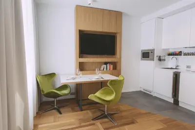 a kitchen with a table and two green chairs at Dragon's Den in Ljubljana