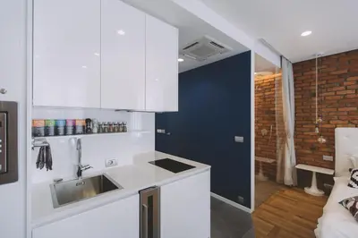 a kitchen with white cabinets and a sink at Dragon's Den in Ljubljana