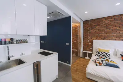 a kitchen with white cabinets and a couch in a room at Dragon's Den in Ljubljana