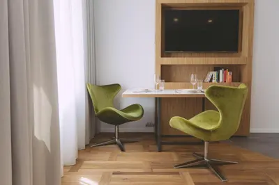 a room with two green chairs and a table with a television at Dragon's Den in Ljubljana