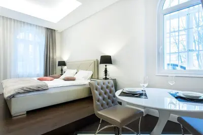 a bedroom with a bed and a table and a dining room at Tivoli Double in Ljubljana