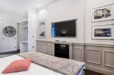 a bedroom with a flat screen tv and a bed at Tivoli Double in Ljubljana