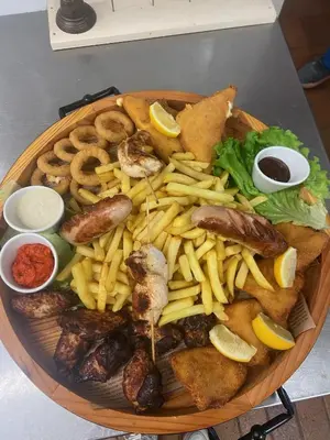 a plate of food with sausage and french fries at Planinski dom Kal in Dol pri Hrastniku
