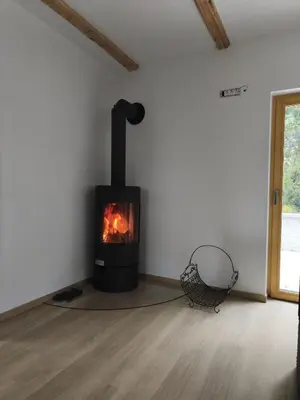 a black fireplace in a room with a wooden floor at Holiday Cabin near Ljubljana - Hawknest