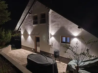 a house with lights on the side of it at night at Holiday Cabin near Ljubljana - Hawknest